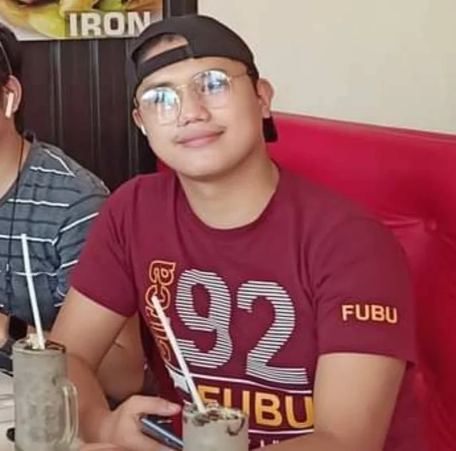 Rechcel wearing glasses and a backward cap at a restaurant table