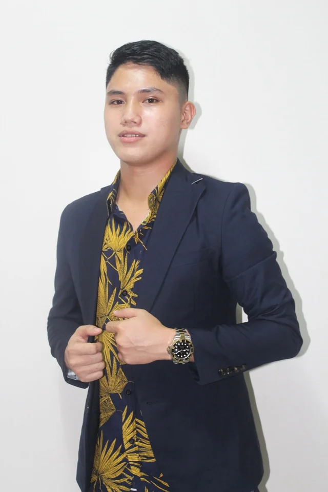 Rechcel in a navy blazer and a yellow patterned shirt